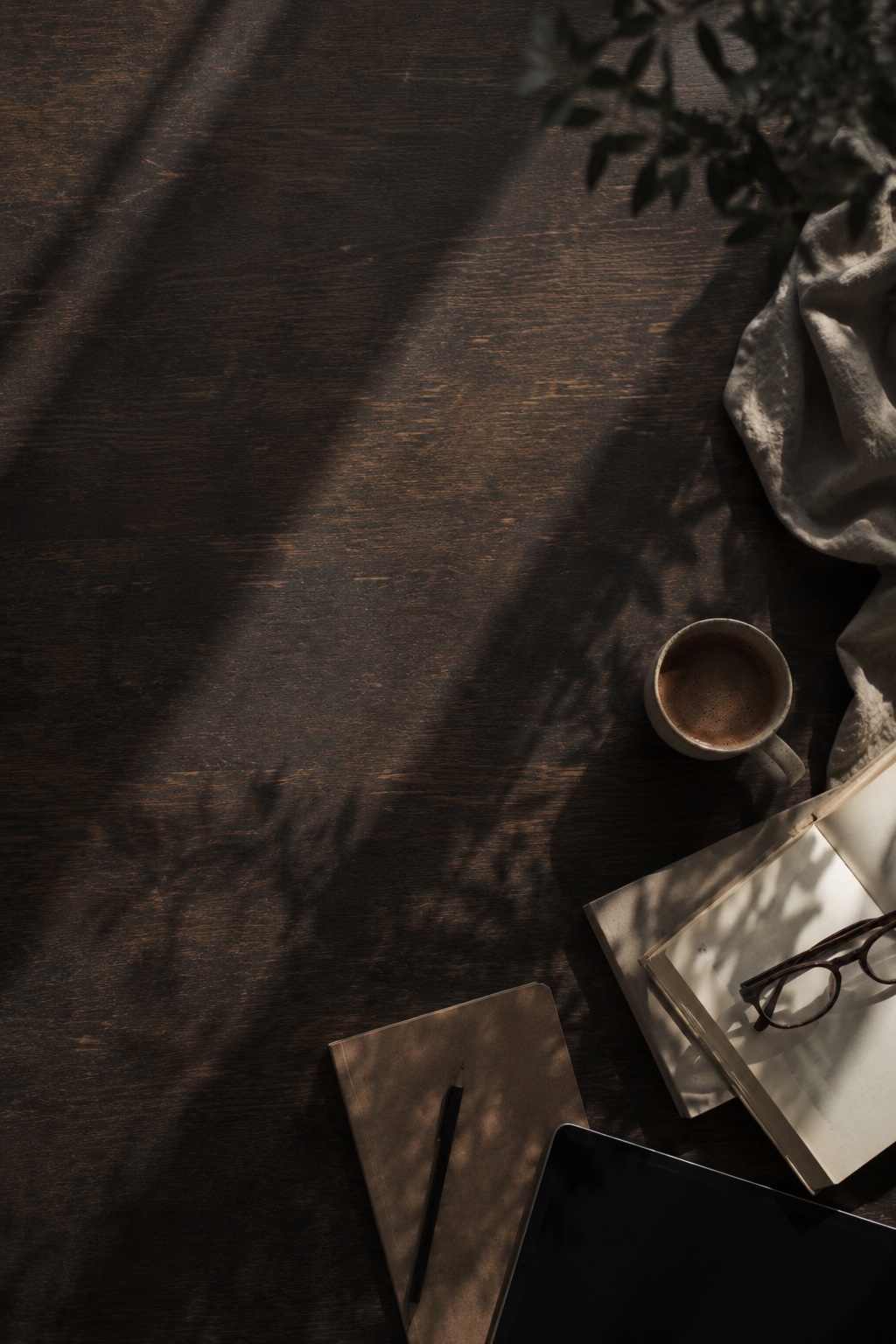 Dunkles Stillleben mit Mushroom Coffee, Buch und Notizbuch