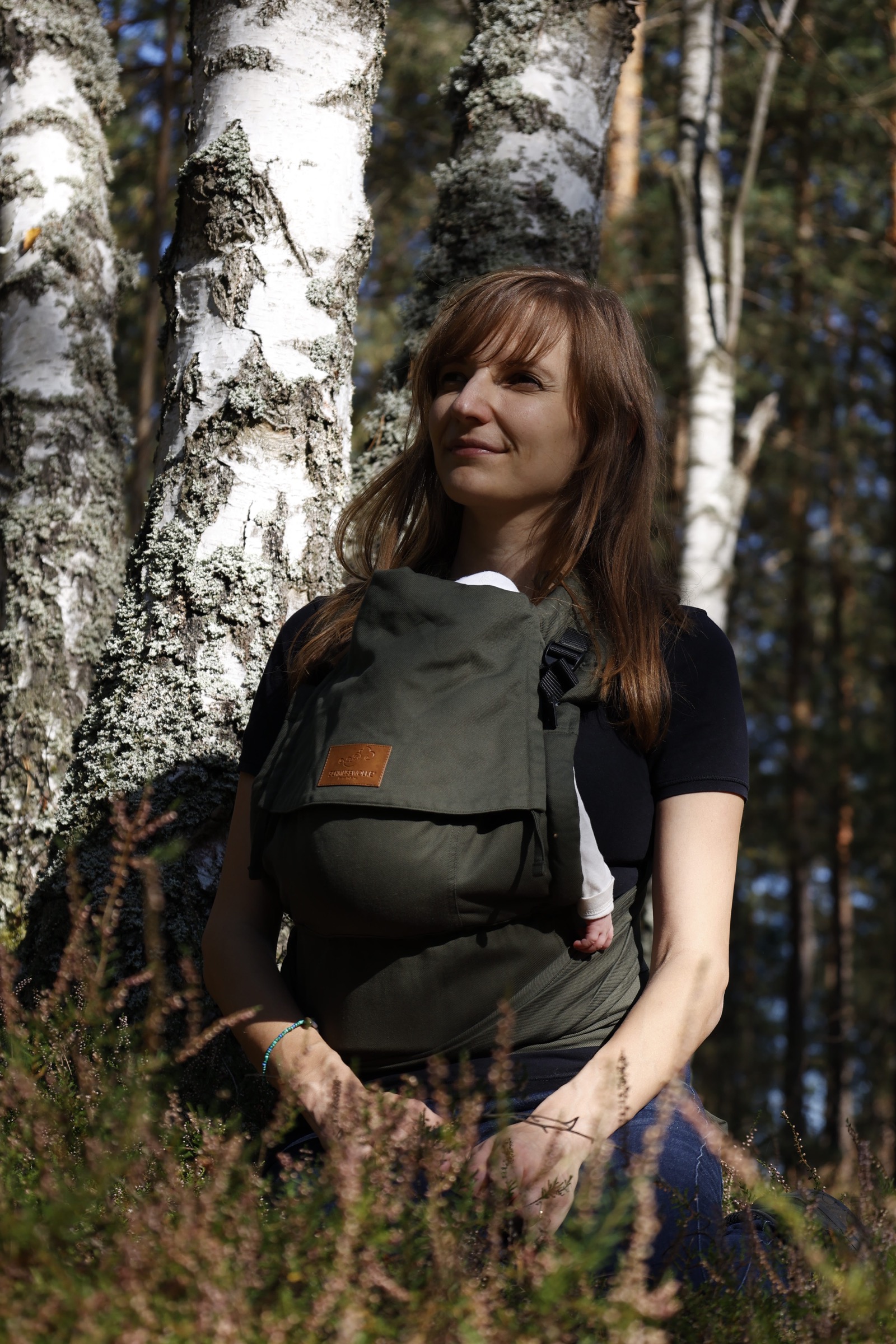 Mutter mit Baby bei einem gemeinsamen Waldmoment im Herbst