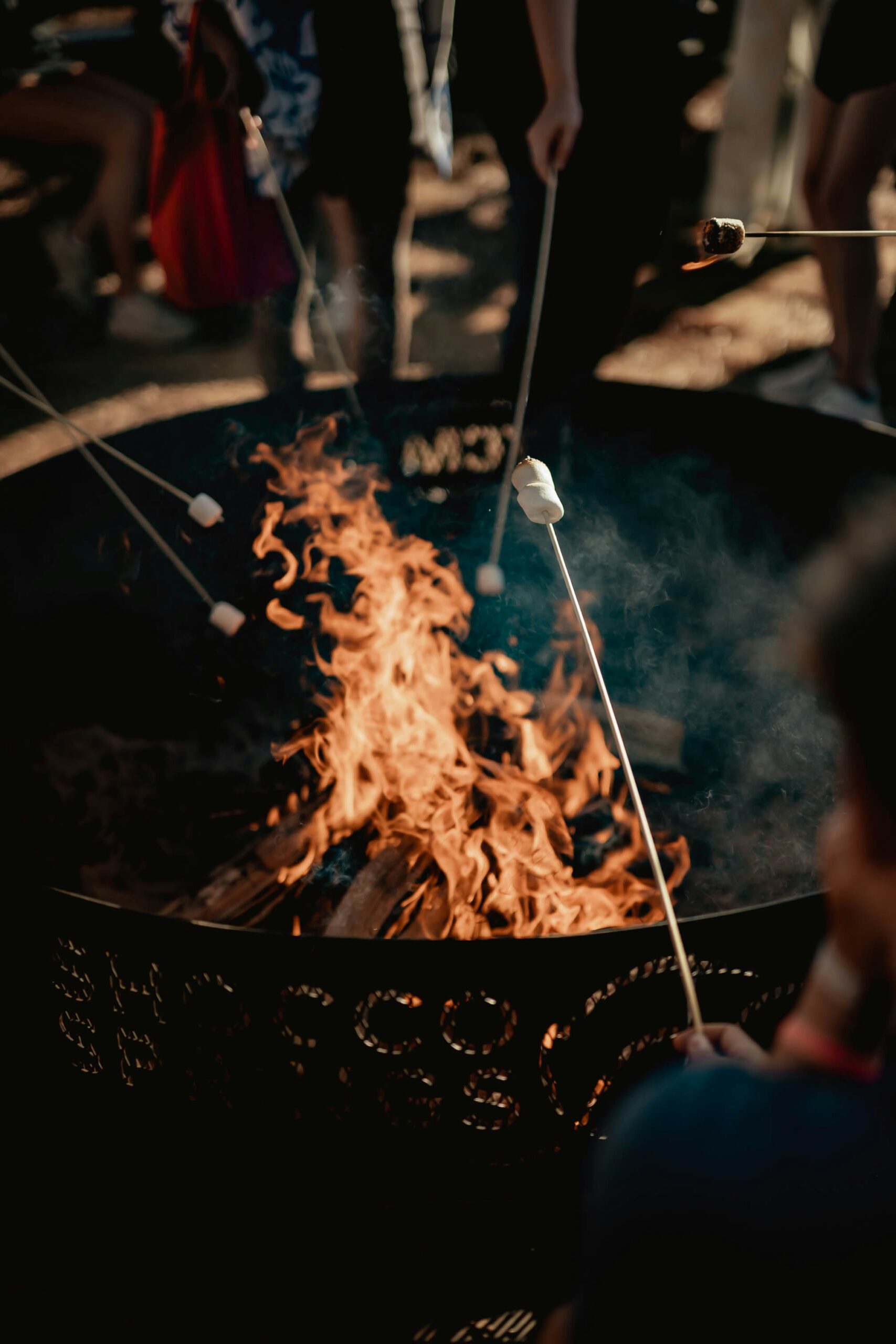 Familie bereitet Stockbrot am Feuer zu